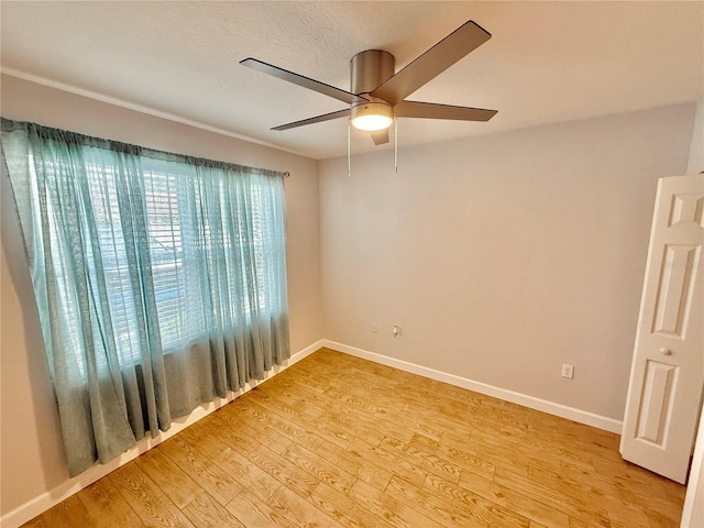 empty room featuring a textured ceiling, light wood-type flooring, and ceiling fan