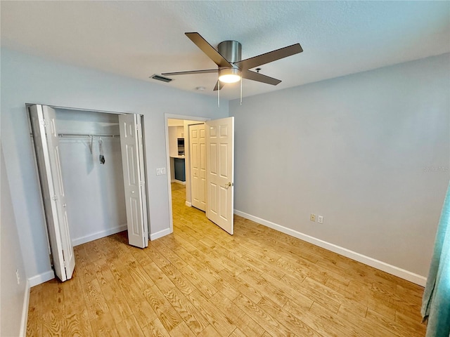 unfurnished bedroom with a closet, ceiling fan, light hardwood / wood-style flooring, and a textured ceiling