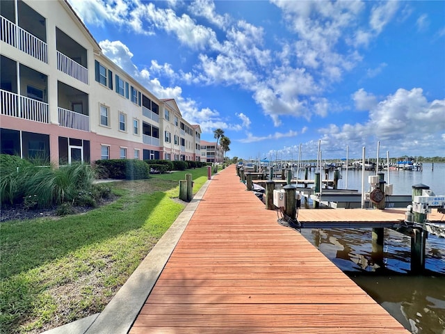 view of dock featuring a water view and a lawn