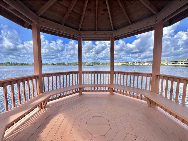 view of dock featuring a deck with water view and a gazebo