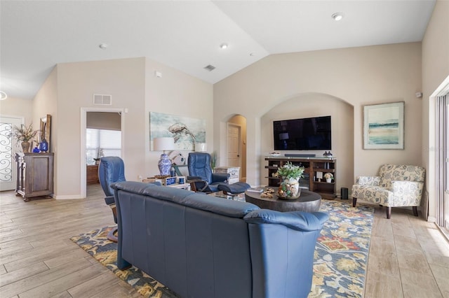 living room with light hardwood / wood-style floors and high vaulted ceiling