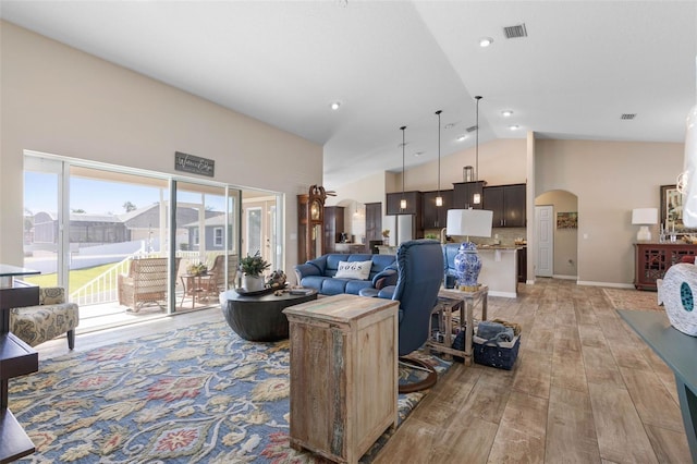 living room with high vaulted ceiling and light wood-type flooring