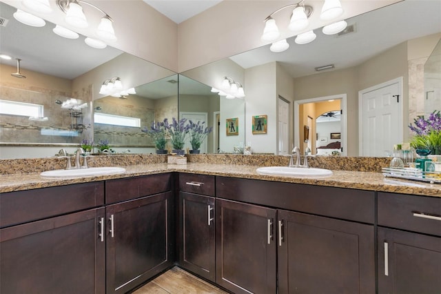 bathroom featuring a tile shower and vanity