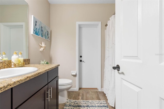 bathroom with vanity, wood-type flooring, and toilet