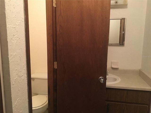 bathroom featuring vanity and toilet