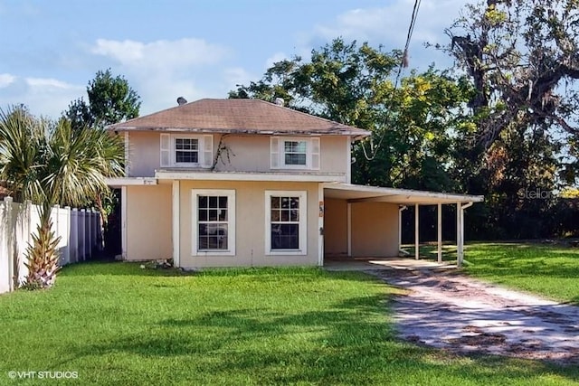 back of property with a carport and a lawn