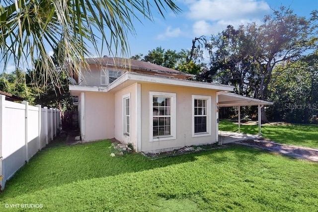 exterior space featuring a yard and a carport