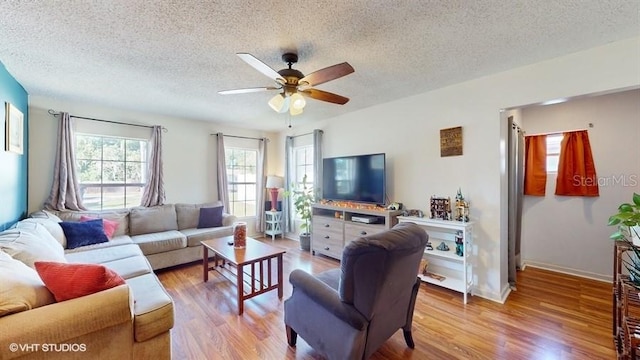 living room with wood-type flooring, a textured ceiling, and ceiling fan