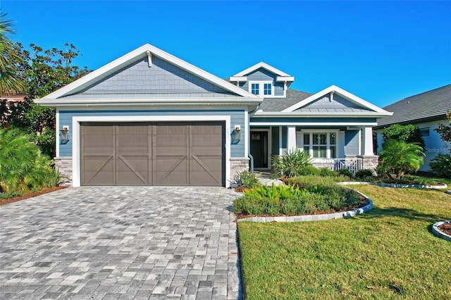 craftsman-style house featuring a front lawn, a porch, and a garage