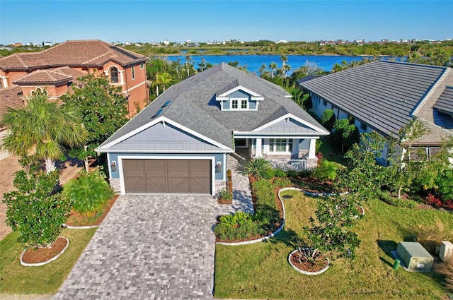 view of front facade with a front yard, a water view, and a garage