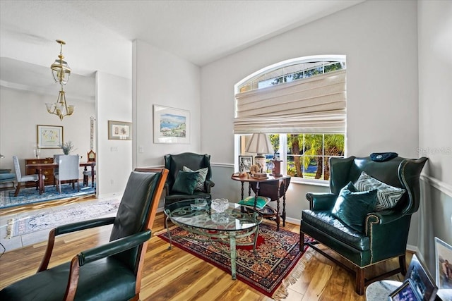 living area with hardwood / wood-style flooring, a wealth of natural light, and a chandelier