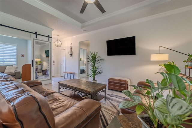 tiled living room with a barn door, ceiling fan, and ornamental molding