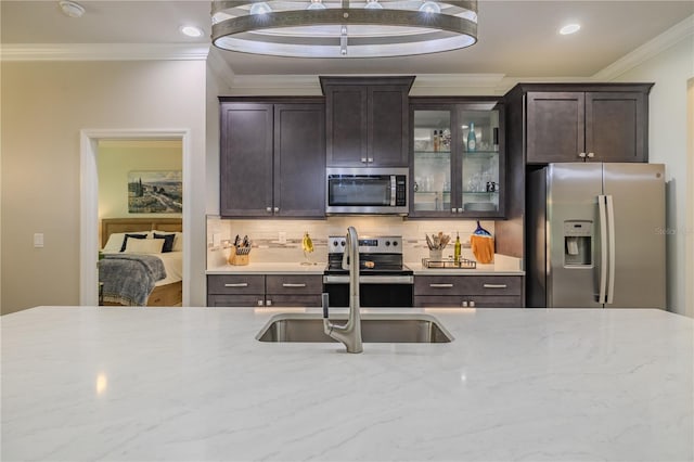 kitchen with crown molding, dark brown cabinets, stainless steel appliances, and sink