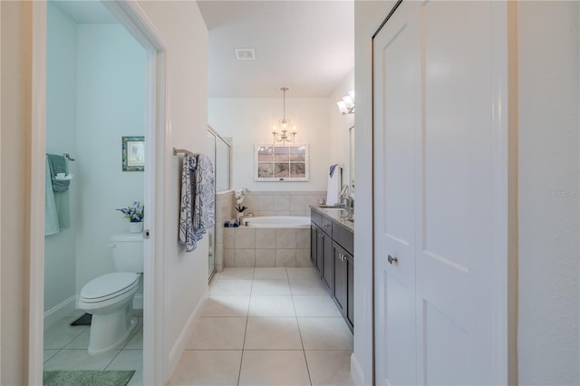 bathroom featuring an inviting chandelier, tile patterned flooring, tiled bath, toilet, and vanity