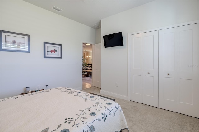 bedroom featuring light colored carpet and a closet