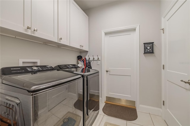 washroom featuring cabinets, washer and dryer, and light tile patterned flooring