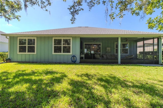 rear view of house with a yard and a sunroom