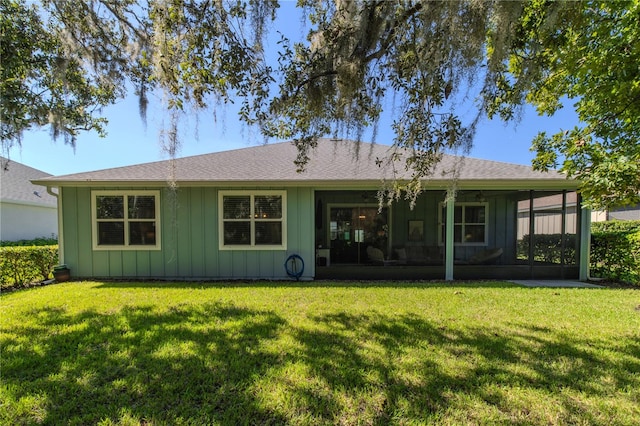 rear view of house with a lawn and a sunroom