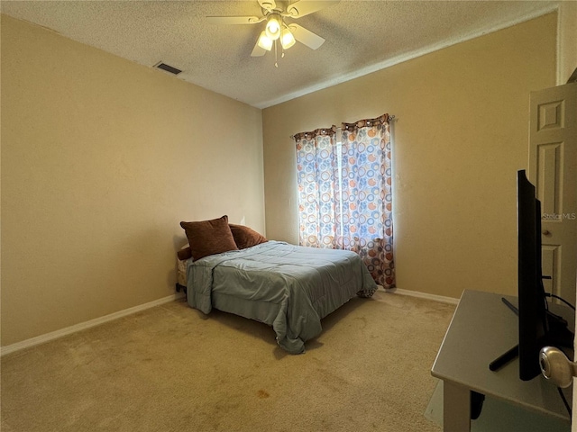 carpeted bedroom with ceiling fan and a textured ceiling