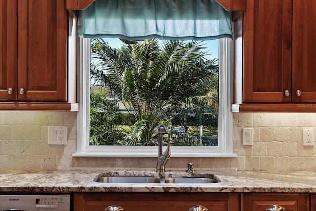 kitchen with dishwashing machine, sink, light stone counters, and plenty of natural light