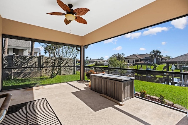 sunroom / solarium with ceiling fan, a water view, and a hot tub