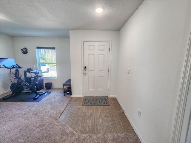 entryway featuring carpet flooring and a textured ceiling