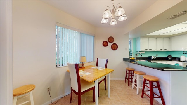 tiled dining area with a notable chandelier and sink