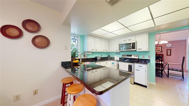 kitchen featuring sink, an inviting chandelier, range with electric stovetop, kitchen peninsula, and white cabinets