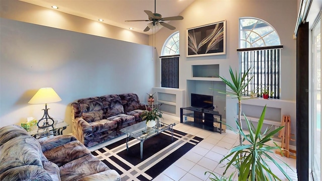 living room featuring built in shelves, ceiling fan, light tile patterned flooring, and a high ceiling