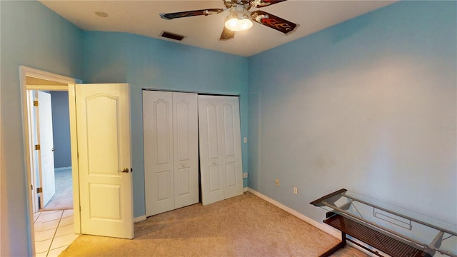 unfurnished bedroom with light carpet, a closet, and ceiling fan