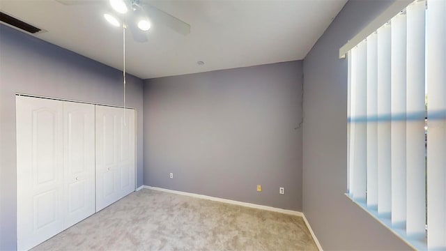 unfurnished bedroom featuring ceiling fan, a closet, and light carpet