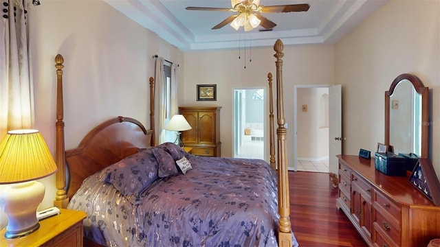 bedroom featuring a raised ceiling, ceiling fan, and dark hardwood / wood-style floors