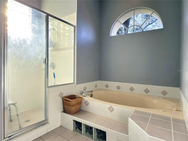 bathroom featuring tile patterned flooring and separate shower and tub