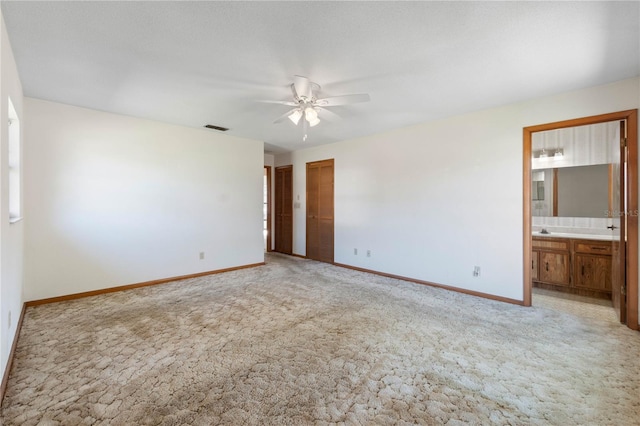 empty room featuring ceiling fan, light colored carpet, and sink