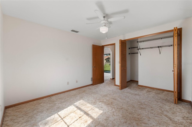 unfurnished bedroom featuring ceiling fan, a closet, and light colored carpet