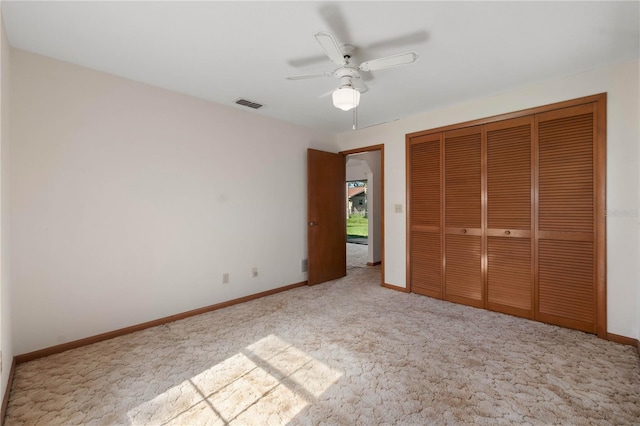 unfurnished bedroom with ceiling fan, a closet, and light carpet