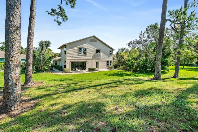 rear view of property featuring a yard and a patio