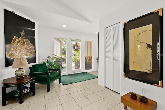 doorway with lofted ceiling and light tile patterned floors