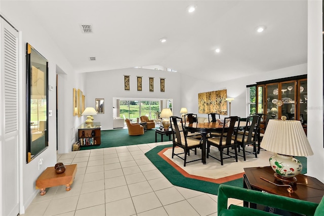 tiled dining space with lofted ceiling