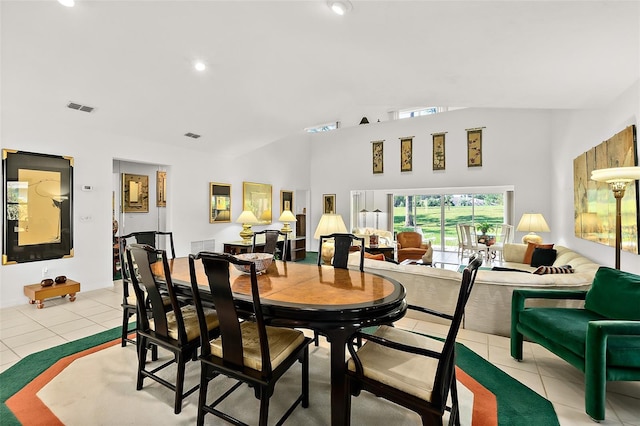 dining space featuring light tile patterned flooring and lofted ceiling