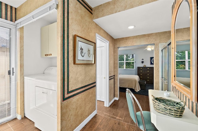 interior space featuring washing machine and clothes dryer, cabinets, and dark wood-type flooring