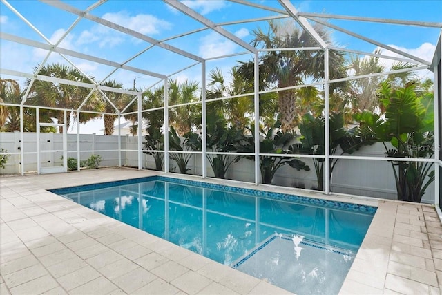 view of pool featuring glass enclosure and a patio area