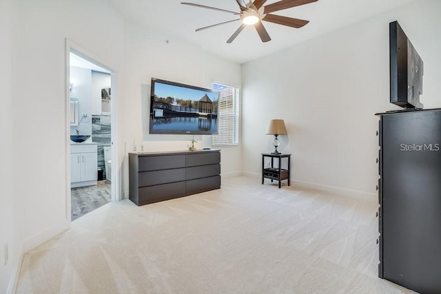 carpeted bedroom with connected bathroom and ceiling fan