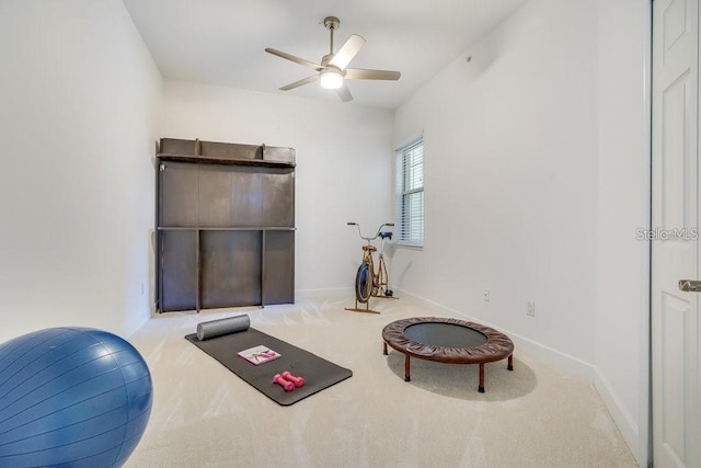 exercise area featuring ceiling fan and light colored carpet