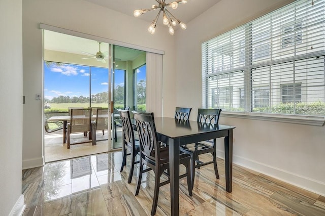 dining space with light wood-type flooring and ceiling fan with notable chandelier