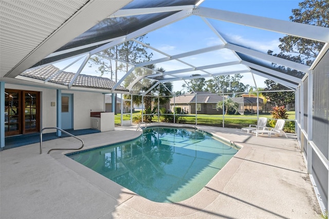 view of pool featuring glass enclosure and a patio