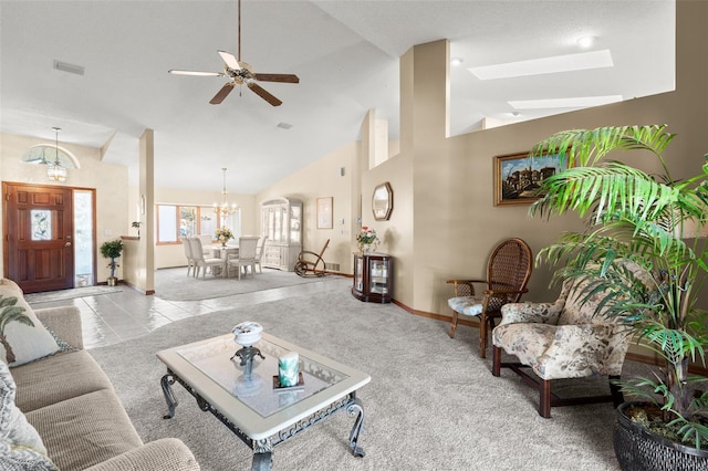 carpeted living room with high vaulted ceiling and ceiling fan with notable chandelier