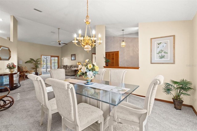 carpeted dining space featuring ceiling fan with notable chandelier and vaulted ceiling