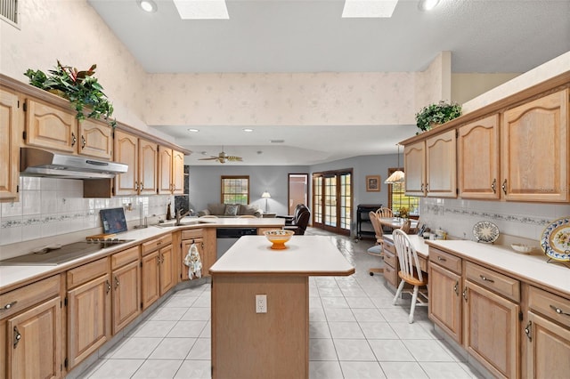 kitchen with cooktop, a skylight, dishwasher, and a kitchen island