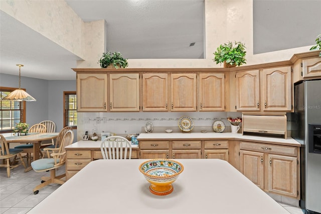 kitchen with pendant lighting, stainless steel fridge, light tile patterned flooring, and light brown cabinetry